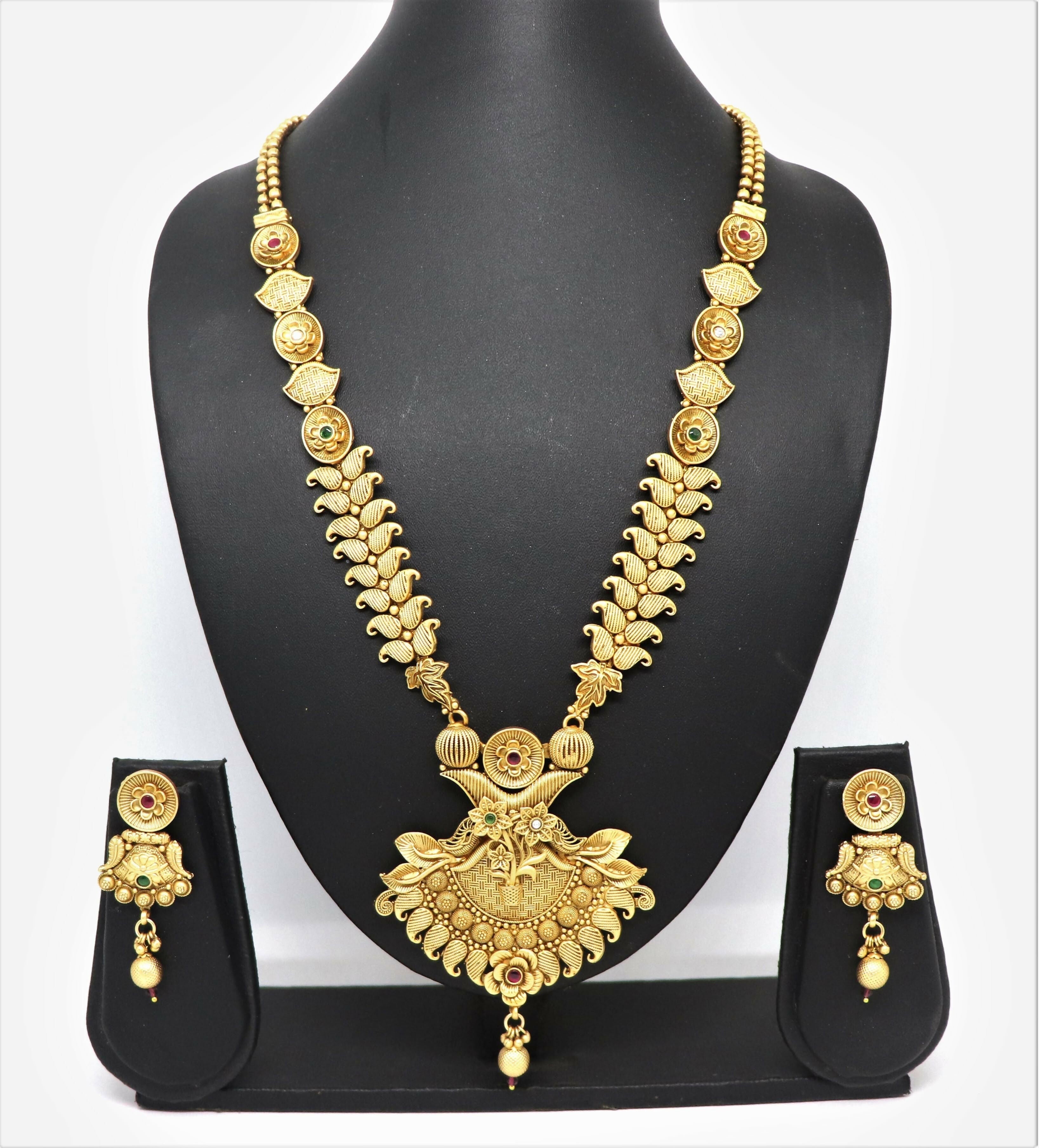 Close up of a traditional gold mango design brass necklace set with Rajwadi polish and stone embellishments.