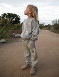 Child wearing a comfortable WWJD Varsity Kids Crewneck with a relaxed, oversized fit.