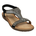 A side-angle view of a black t-strap flat sandal with rhinestone embellishments and an elastic slingback strap on a white background.
