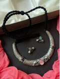 A decorative oxidized brass choker necklace set with vibrant Monalisa stones and matching earrings