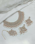 White stone necklace set with earrings and tikka, featuring intricate craftsmanship
