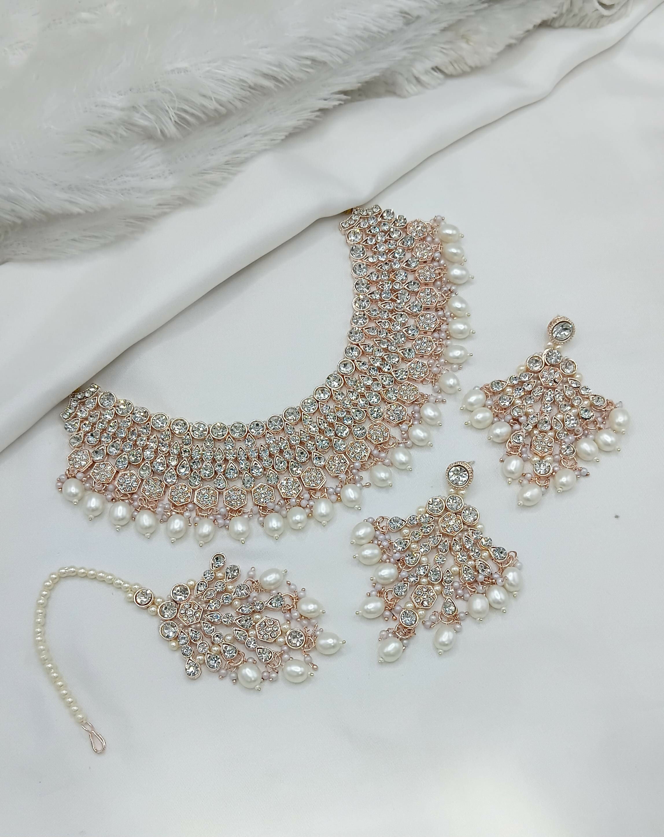 White stone necklace set with earrings and tikka, featuring intricate craftsmanship