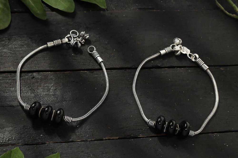 Oxidised silver anklets with black bead accents, displaying a traditional Kamal Johar aesthetic.