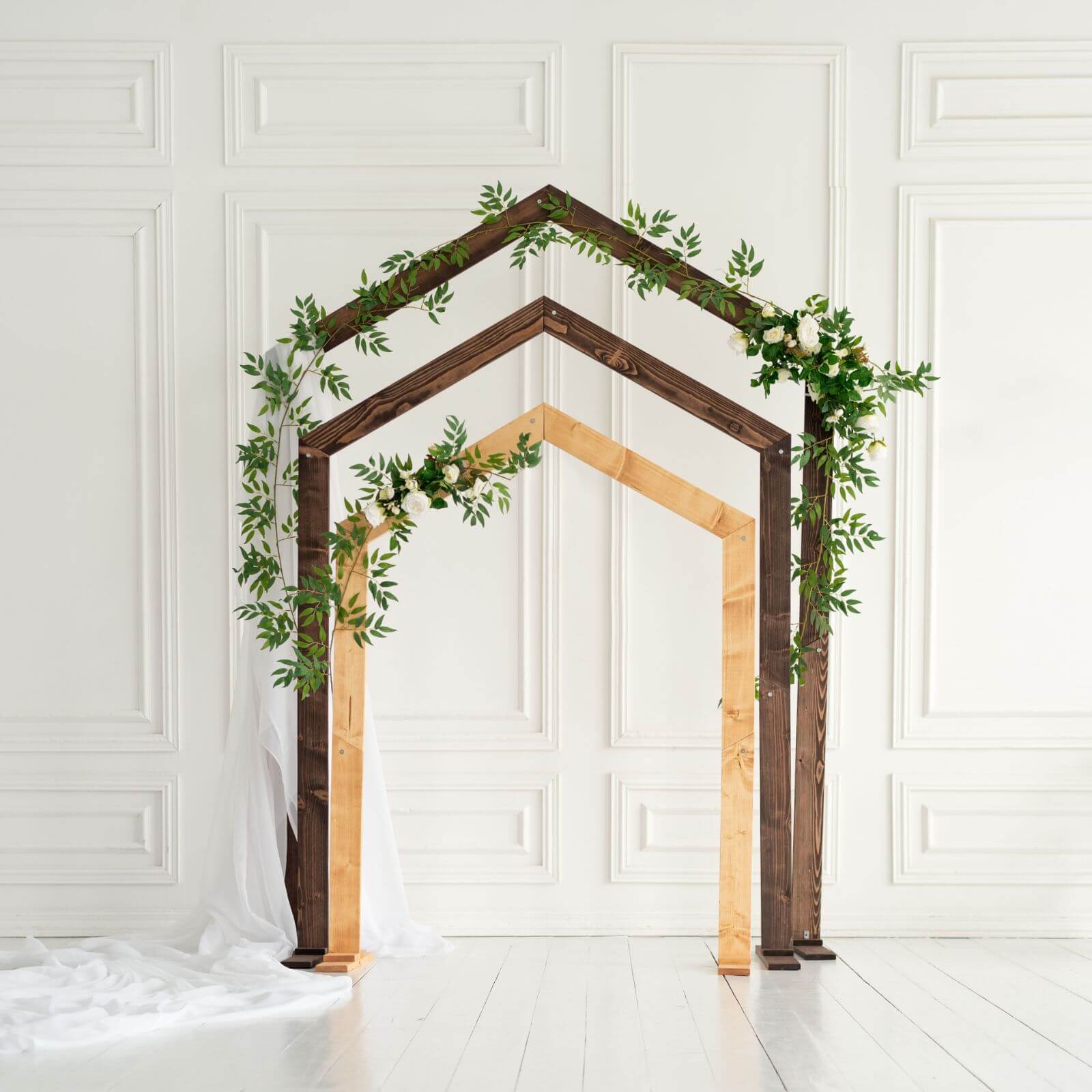 Pentagon-shaped wooden wedding arch for ceremony decor, decorated with floral accents