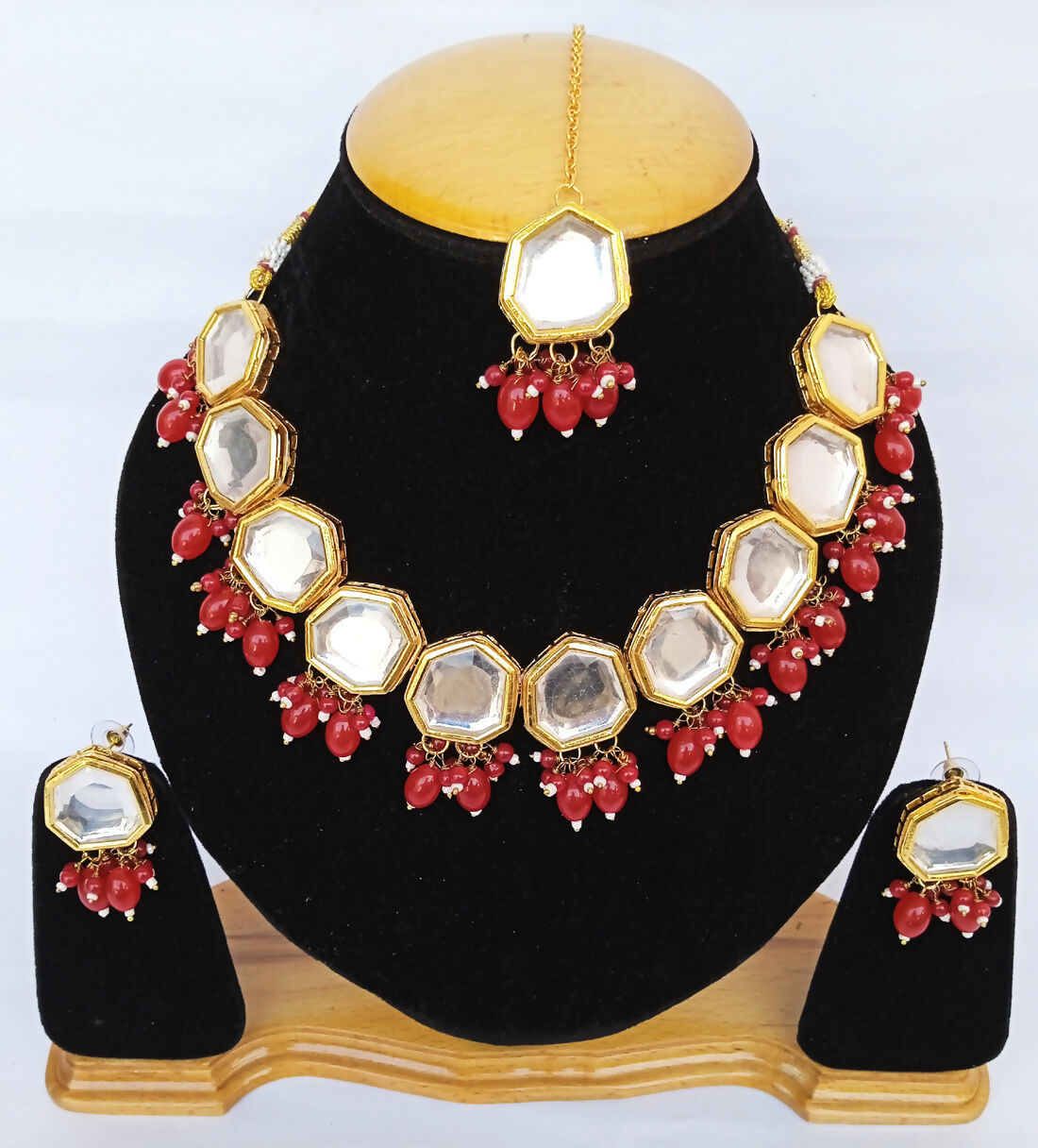 Elegant red Kundan necklace set featuring gold-plated finish and adjustable cord for traditional women's wear