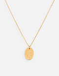 Close-up of a gold oval pendant wildflower necklace with a polished finish worn on a delicate cable chain.