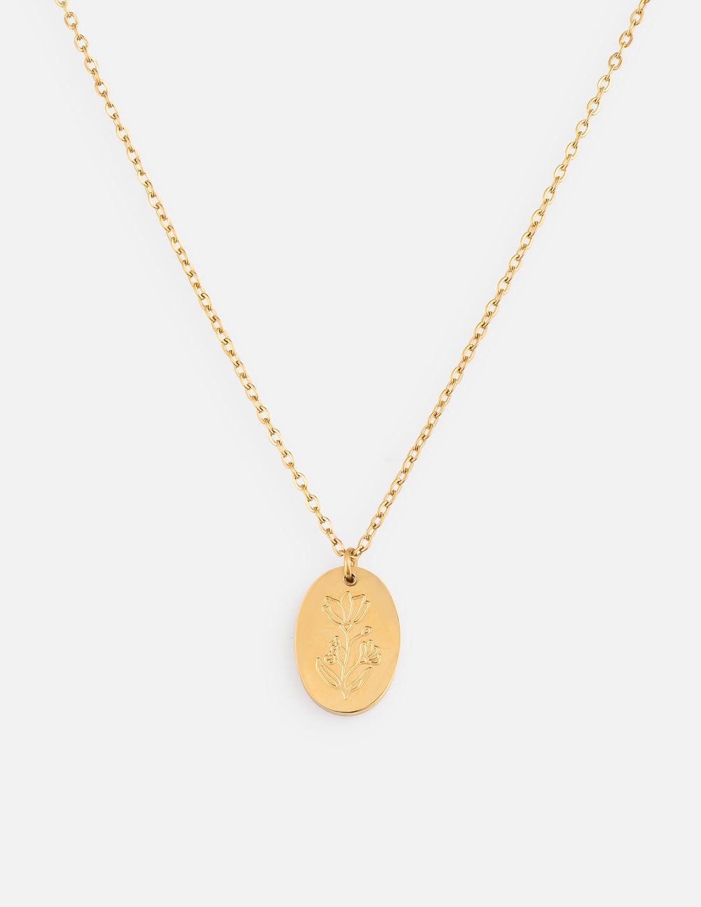 Close-up of a gold oval pendant wildflower necklace with a polished finish worn on a delicate cable chain.