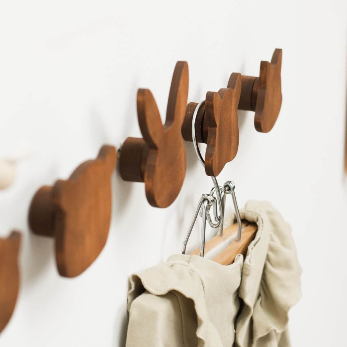 Wooden animal-shaped wall hooks in a brown finish, perfect for a forest-themed nursery.