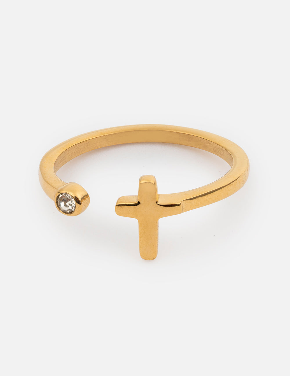 Delicate gold-toned ring with a wrapped cross design and a small bezel-set crystal, viewed from a close-up angle.