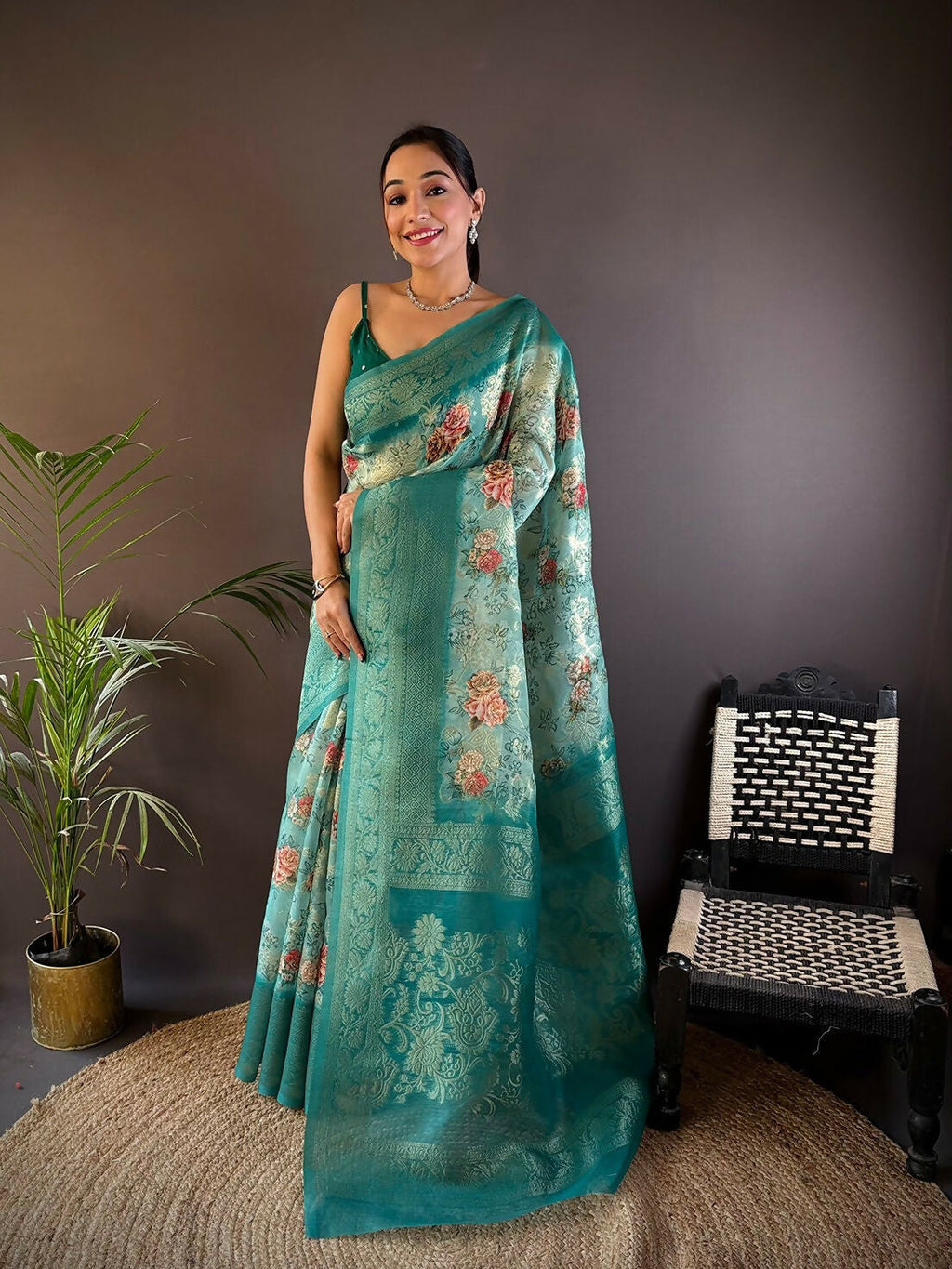 Teal Banarasi silk saree featuring intricate floral motifs and matching unstitched blouse fabric