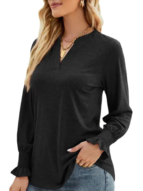 Woman wearing a solid long sleeve V-neck sweatshirt with ruffled smocked cuffs