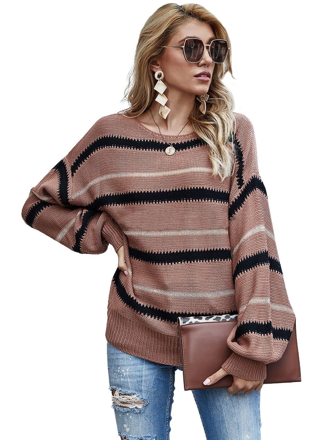 Woman wearing a brown, black, and beige striped crew neck oversized knit sweater