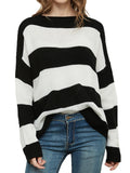 A woman wearing a black and white horizontal striped crew neck long sleeve sweater with a relaxed fit.