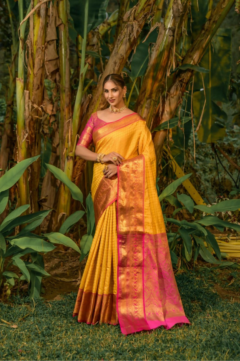 Yellow Kanjivaram silk saree featuring Zari woven patterns with an included pink blouse.