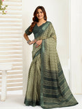 Woman wearing a cream linen ready-to-wear saree with zig-zag chevron patterns and a dark green blouse