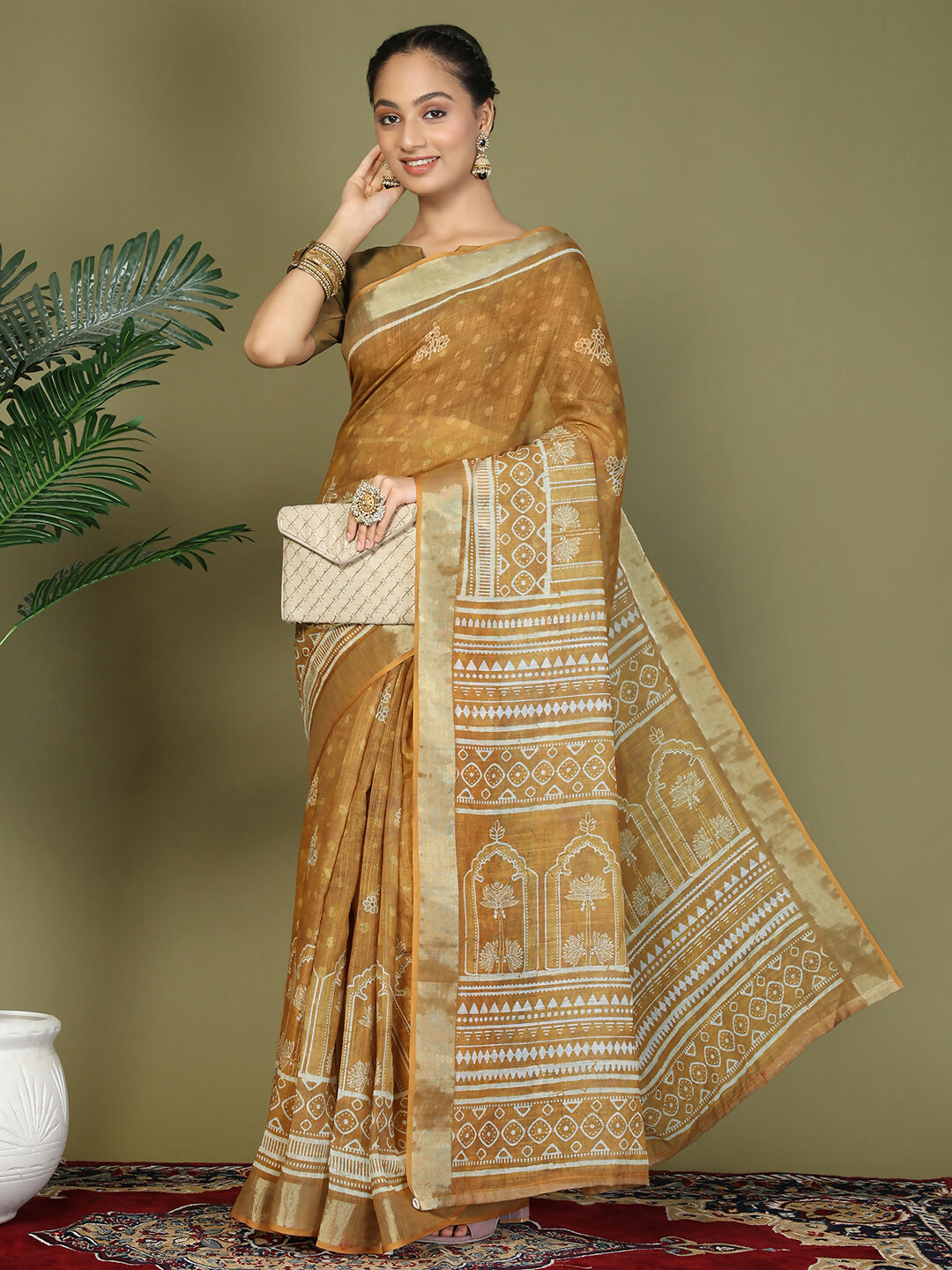 Woman wearing a golden-brown and mustard ethnic cotton saree with short sleeves.