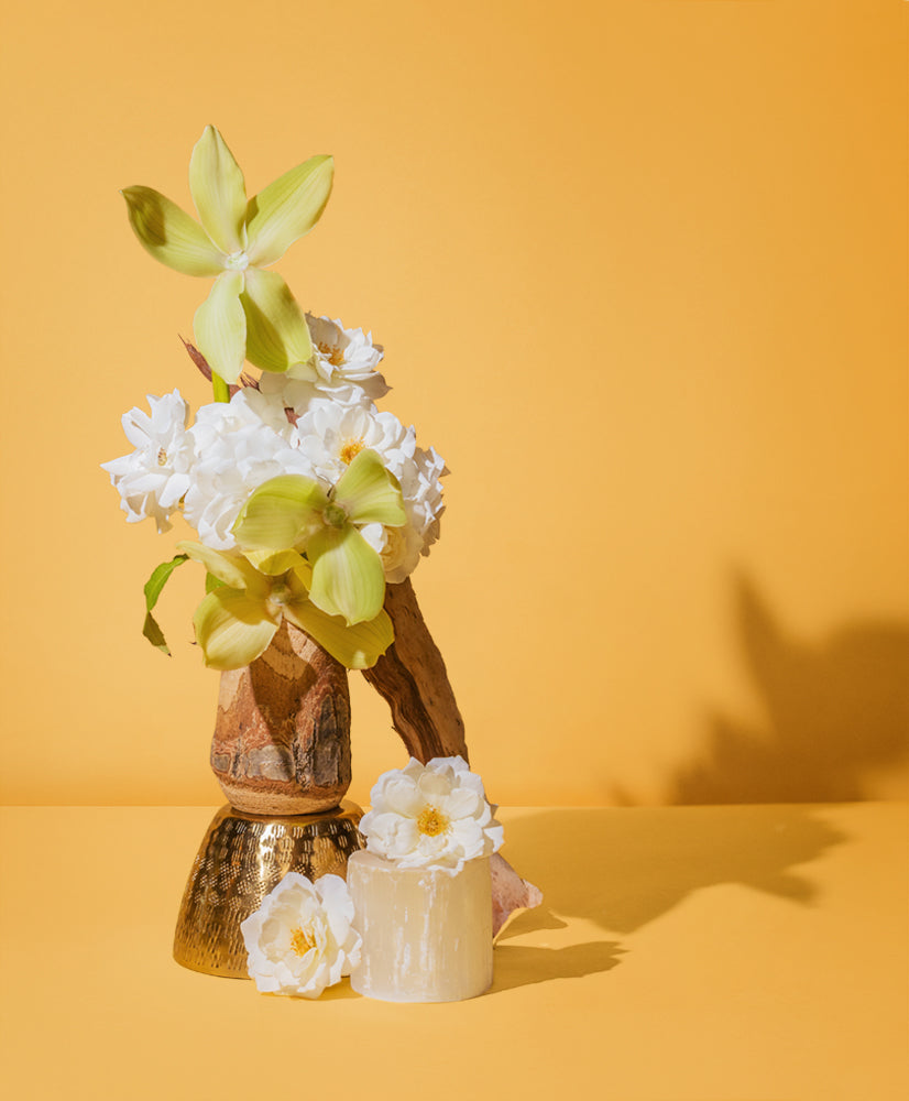 Ylang and Geranium natural fragrance oil marketing imagery featuring white floral arrangements against a vibrant yellow background
