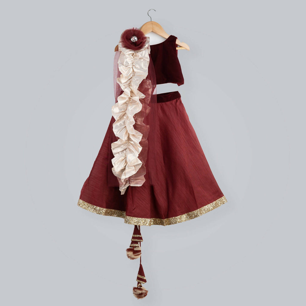 Girl's red ghagra choli with maroon velvet sleeveless top and net dupatta with gold frill