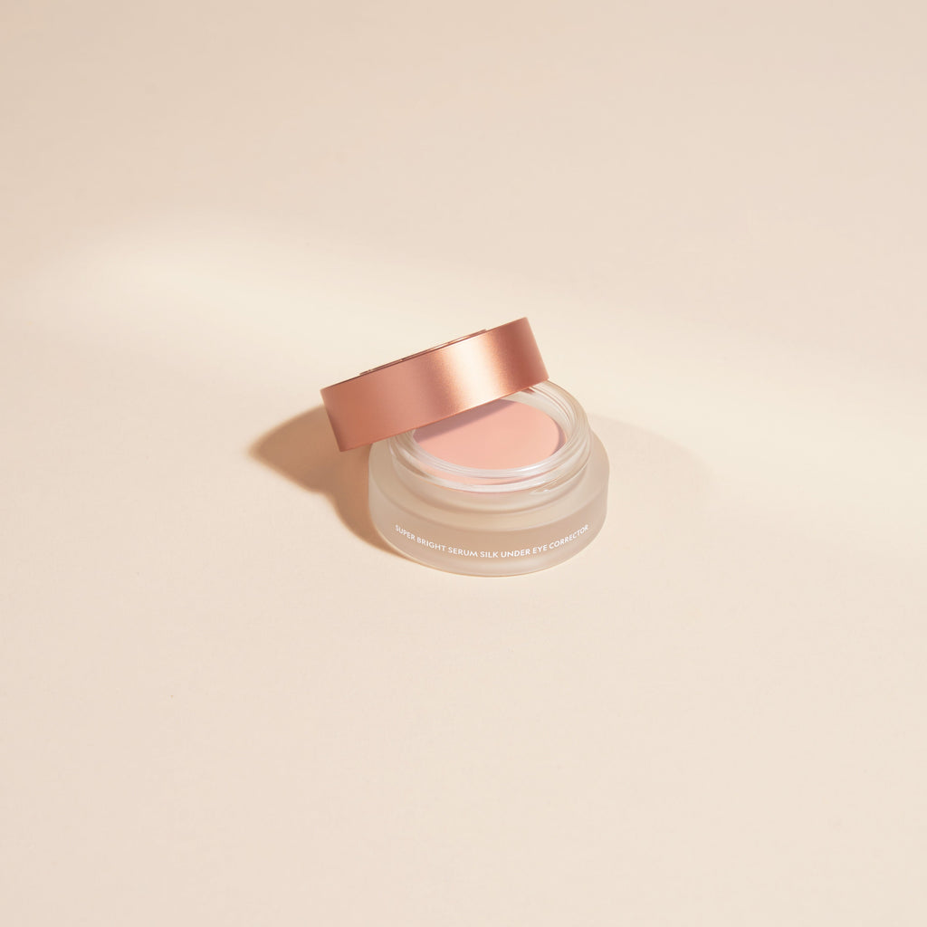 Close up of Yensa Super Bright Dark Circle Serum Peptide Corrector in a glass jar with a rose gold lid.