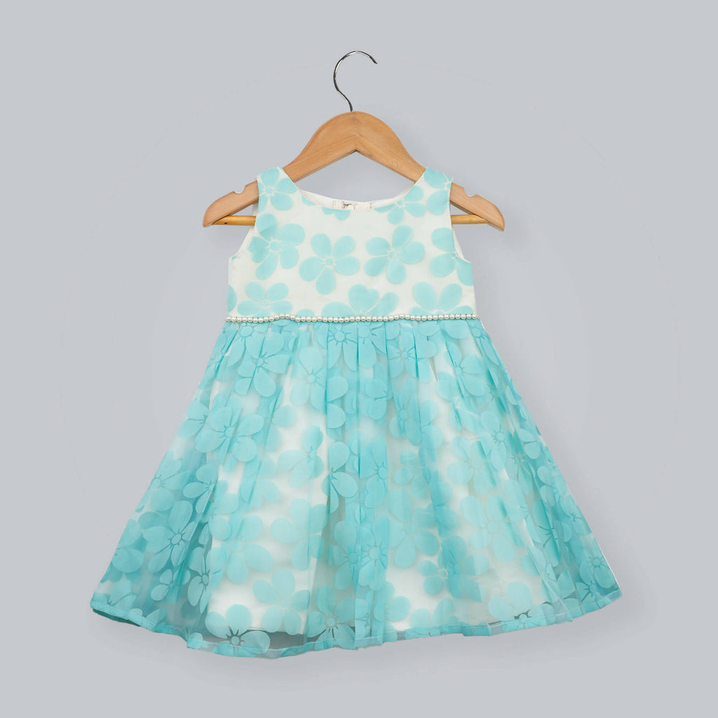 A classic white and blue floral organza gown with pearl waist detailing and a large back bow.