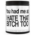 12oz black tin candle featuring witty text, placed next to a wine glass and home decor.