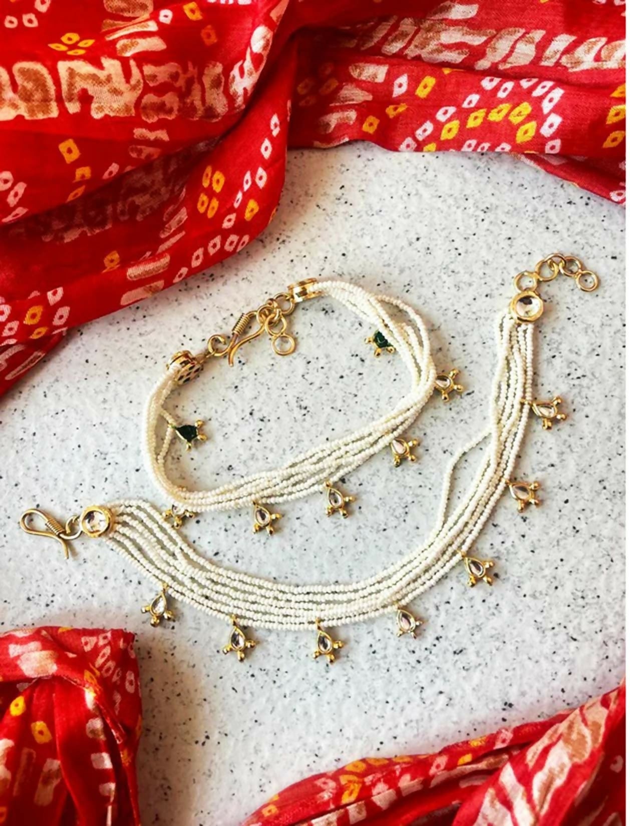 Elegant white bead and Kundan anklet with gold-plated accents, featuring pear-cut crystals in a bohemian style.