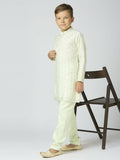 A young boy wearing a Pista green Chanderi kurta and pyjama set with intricate traditional buta work.