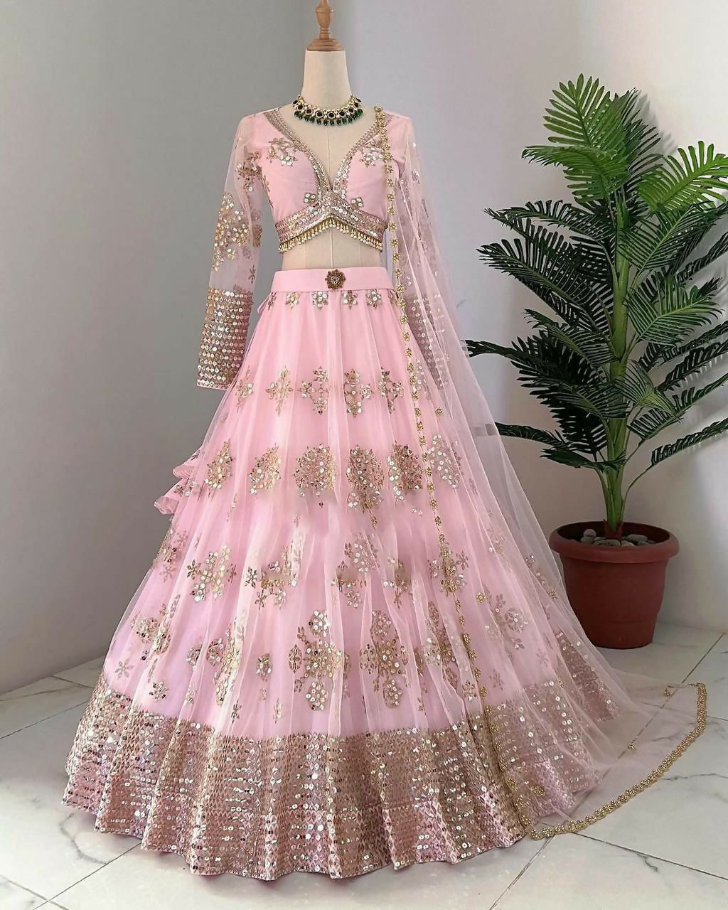 Baby girl wearing a baby pink butterfly net lehenga choli with sequins and embroidery