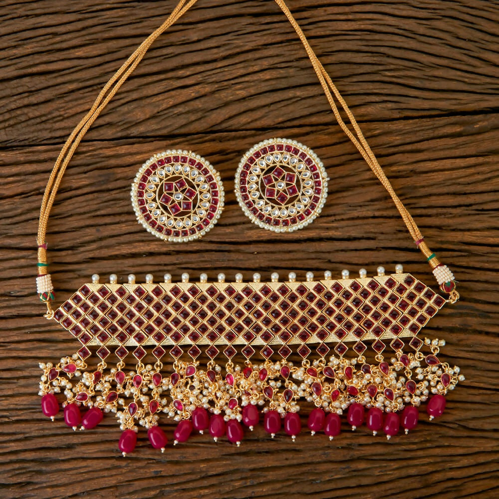 Golden White Ruby necklace set featuring Kundan, pearls, and onyx stone accents