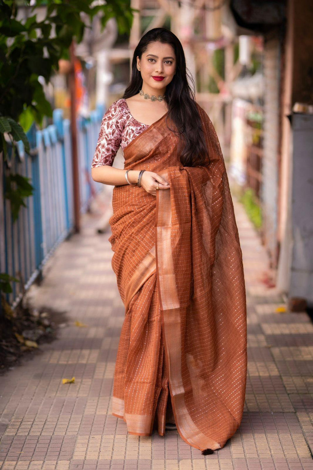 Brown linen saree with self-weaving checks and a traditional golden pattu border