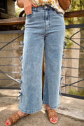 Close-up of blue denim jeans featuring a decorative bow knot detail on the side seam