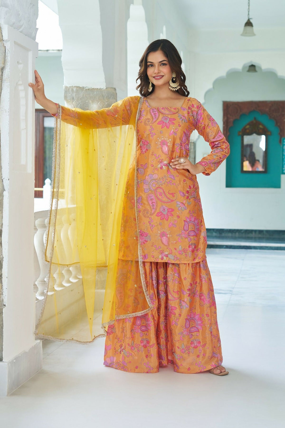 Woman wearing a vibrant yellow Chinnon kurta set with detailed embroidery and sequence work