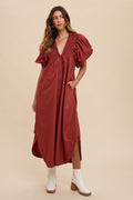Woman wearing a feminine smocked midi dress with dramatic puff sleeves