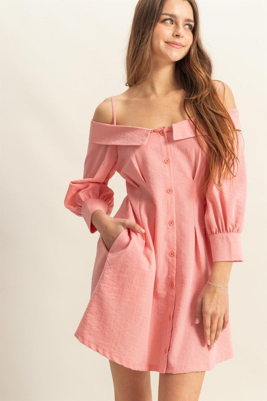 A feminine pink spaghetti strap mini dress with a button-down front and side pockets.