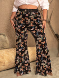 Model wearing black wide-leg pants featuring a vibrant floral and paisley print pattern.