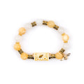 Gold plated bracelet featuring a white chalcedony inlaid cross charm on a white background.