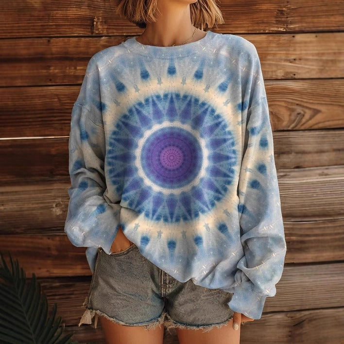 A close-up of a women's long sleeve crew-neck sweatshirt featuring an all-over vibrant abstract print.