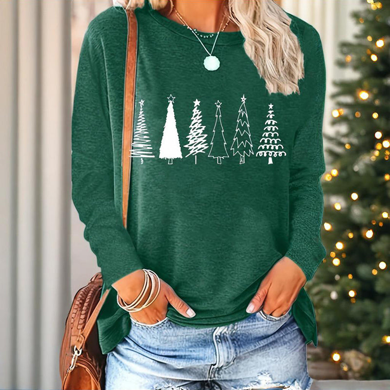 Woman wearing a festive green long sleeve t-shirt with a white Christmas tree graphic print