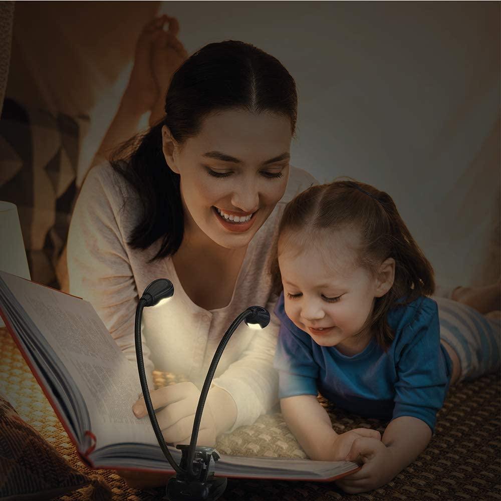 Black double gooseneck LED clip-on lamp attached to a book, illuminating pages with bright, focused light.