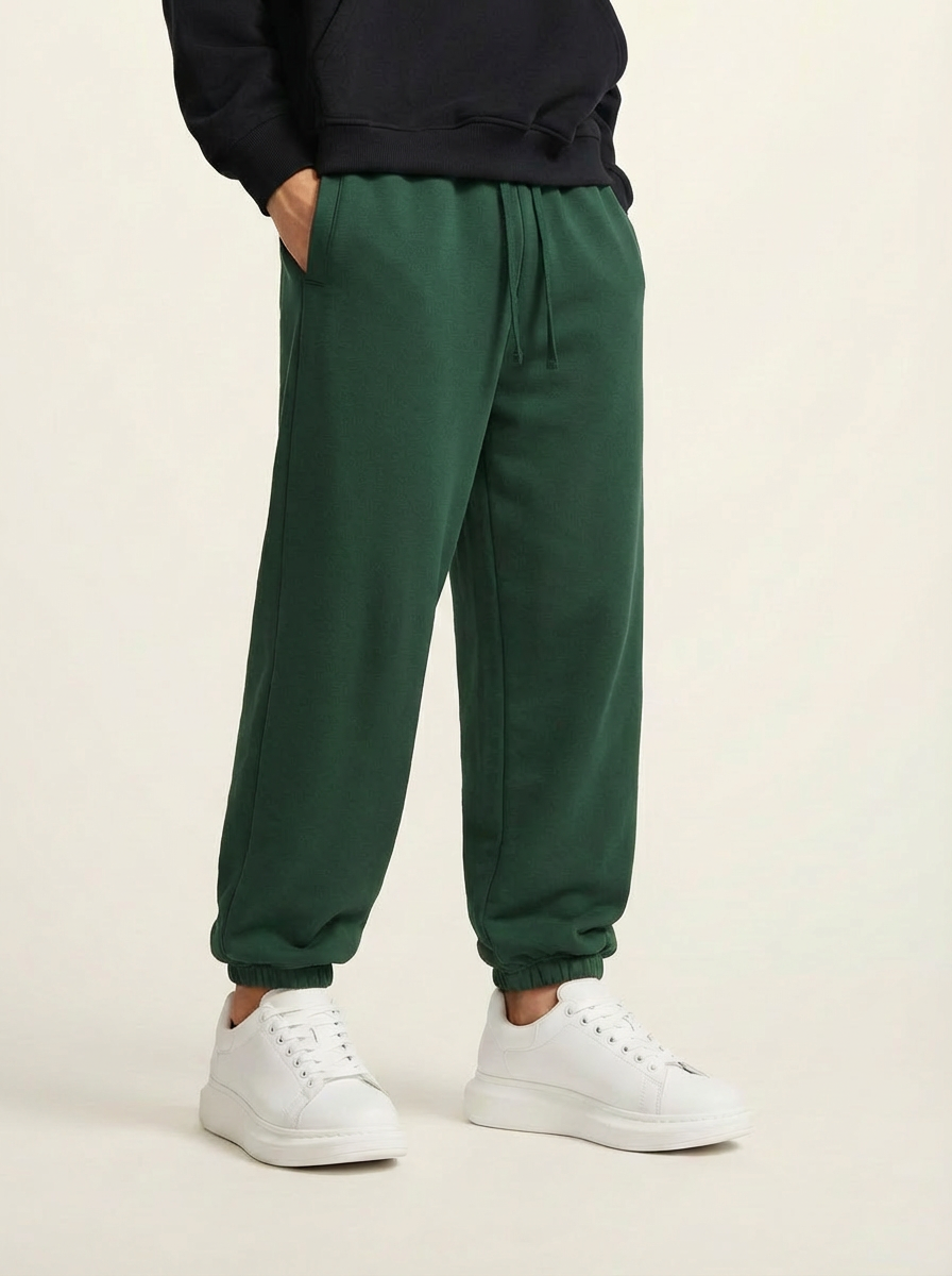 A pair of green heavyweight 440 GSM cotton joggers with a relaxed fit.
