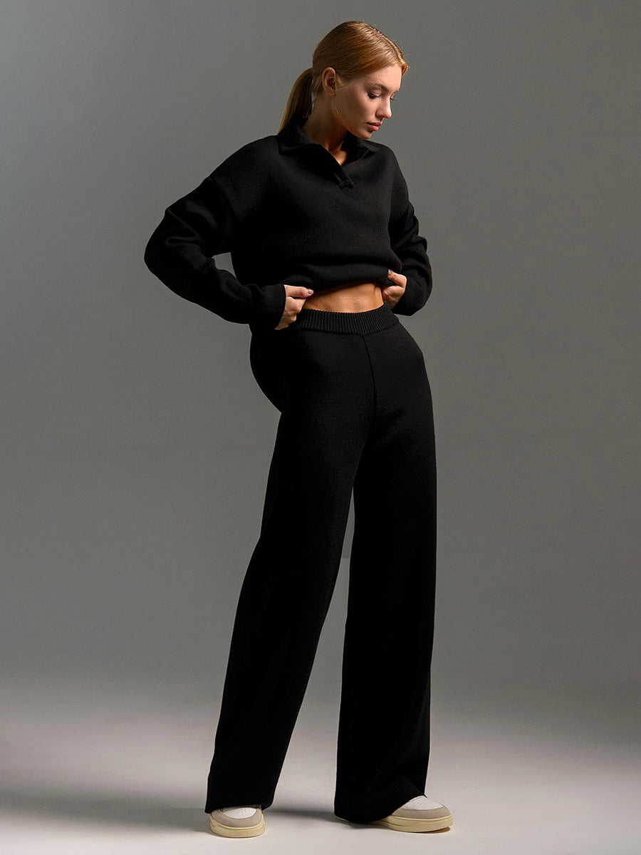 A woman wearing a stylish two-piece set featuring a loose collar sweater and matching trousers in a neutral tone.