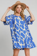 Woman wearing a two-tone abstract print dress with trendy puff sleeves.