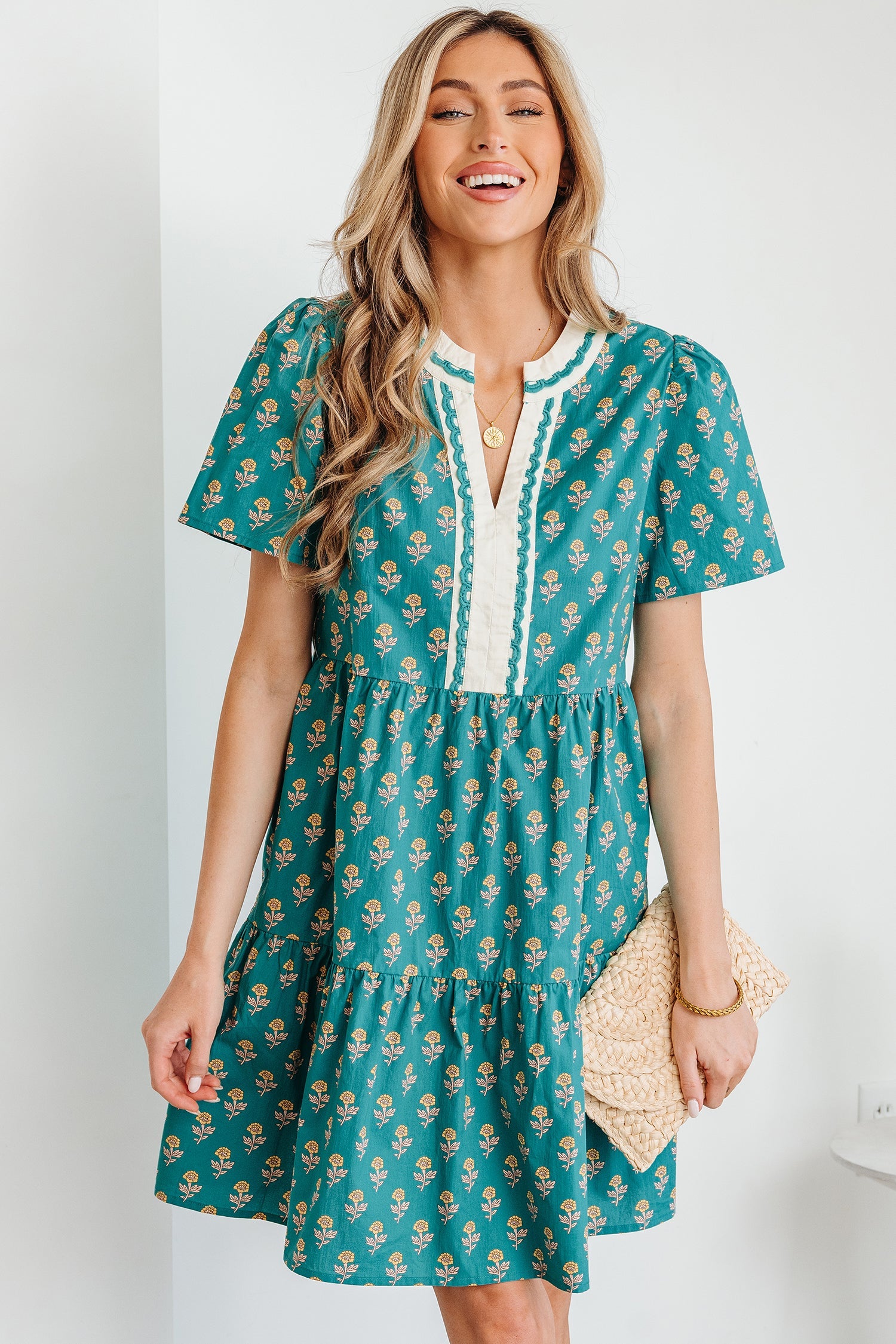 Model wearing a lightweight short sleeve floral dress with V-neck and contrast trim