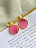 Close up of Monalisa stone elephant-shaped golden stud earrings in a peach hue.