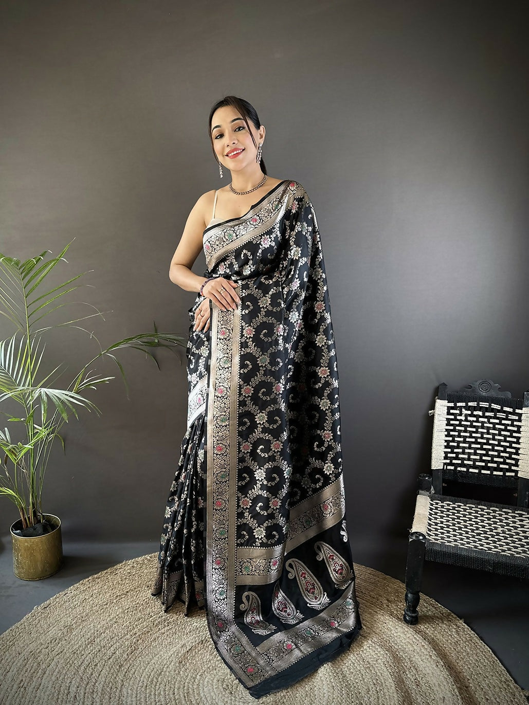 A elegant black Meenakari Banarasi silk saree with vibrant woven patterns and an unstitched blouse piece.