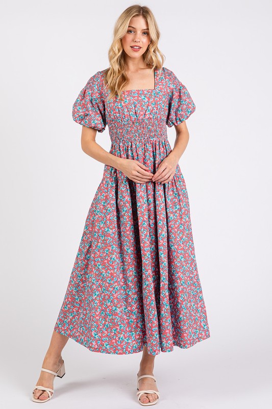 Model wearing a cotton floral smocked midi dress with square neck and puff sleeves