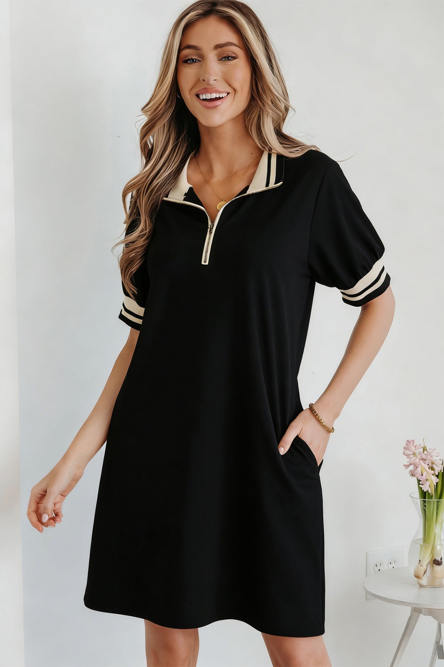 Jovie Trim preppy black and beige polo tee with quarter-zip closure and striped cuff details.