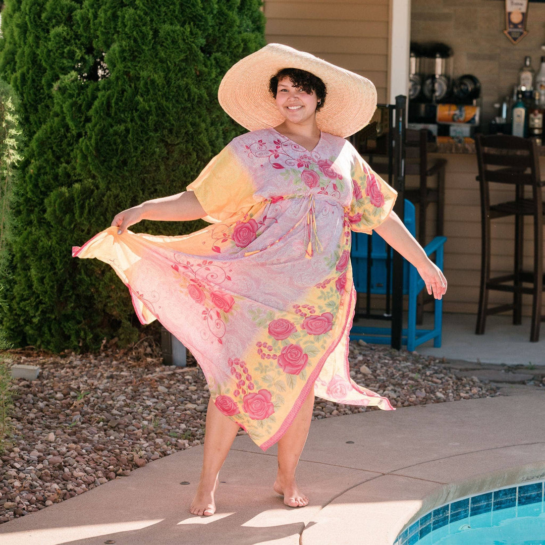 A woman wearing a flowing, unique Aanya adjustable long kaftan dress made from colorful reclaimed sari fabric.
