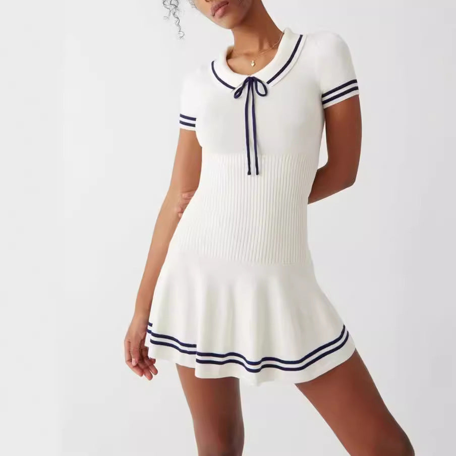 Model wearing a white and navy striped short-sleeve knit mini dress with a polo-style collar