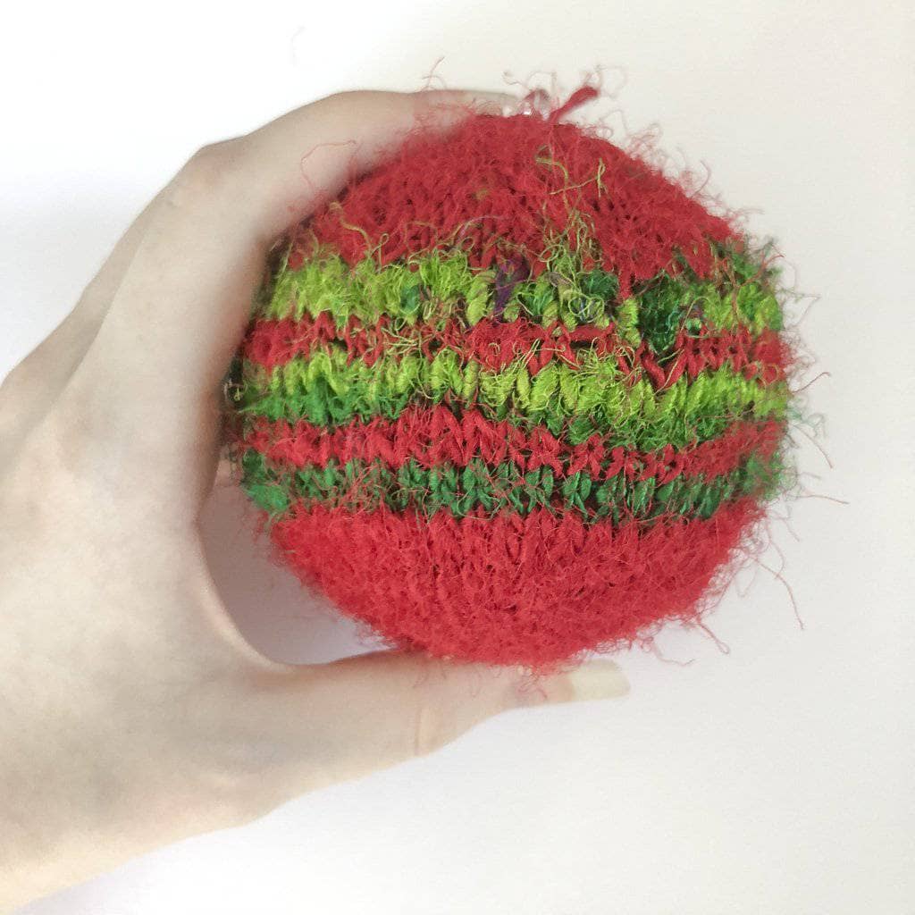 Close up of handmade red and bright green striped knit Christmas ornaments hanging on a tree